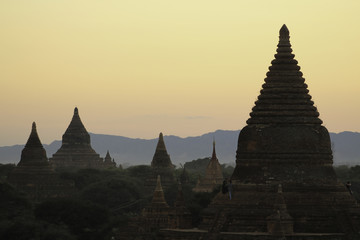 Dusk Silhouette of Temples of Bagan, Myanmar among hazy orange sky. No Balloons in Sight, only a few tourists. A perfect evening.