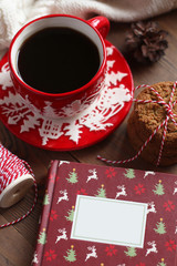 Red Christmas mug with coffee and cookies on the wooden table