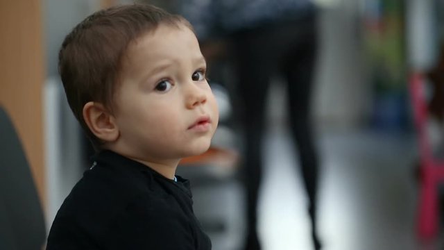 Small boy sitting in the waiting room in hospital
