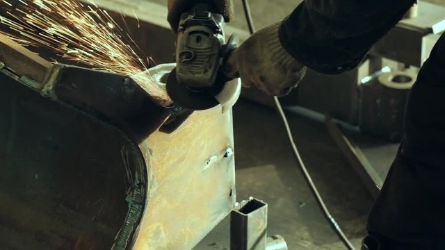 Sparks during cutting of metal angle grinder. Worker using industrial grinder, slow motion, close-up - worker process metal using industrial grinder, colorful sparks fly