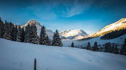 Sunset in Lech, Austria with fog in the village