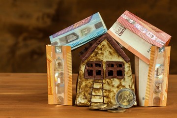 Money to build a house. Concept of mortgage. Valid euro banknotes. Sale of real estate.