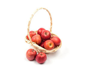Red apples in wicker basket isolated on white .