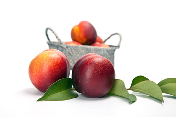 fresh peach fruits with green leaves isolated on white background