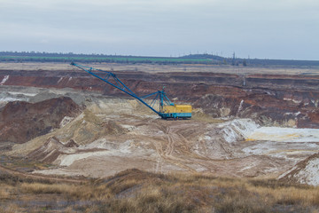 A powerful dragline excavator works in a clay quarry