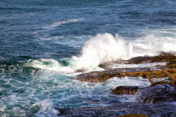 Sea waves crashing against the rocks .