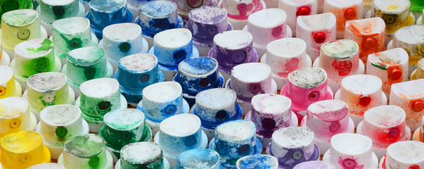 A pattern from a many nozzles from a paint sprayer for drawing graffiti, smeared into different colors. The plastic caps are arranged in many rows forming the color of the rainbow © mehaniq41