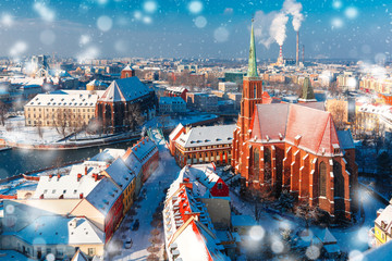 Obraz premium Aerial view of Ostrow Tumski with church of the Holy Cross and St. Bartholomew from Cathedral of St. John in the winter snowy morning in Wroclaw, Poland