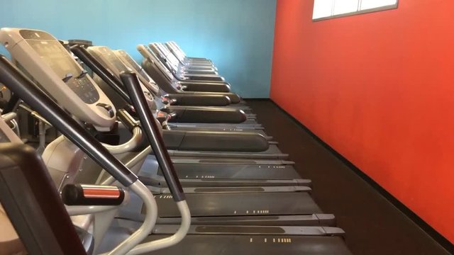 Row of empty treadmills in fitness center