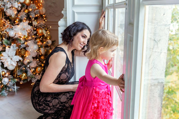 mother and daughter near a Christmas tree