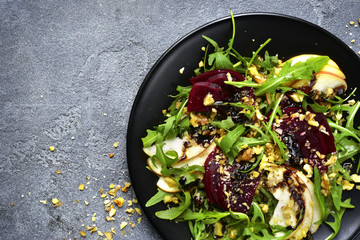 Vegetable salad with beetroot,apple,walnut and arugula leaves.Top view.