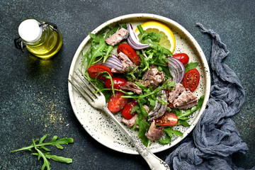 Tuna salad with cherry tomatoes,arugula leaves and red onion.Top view.