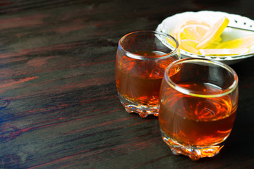 A glass of alcohol and sliced lemon.