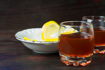 A glass of alcohol and sliced lemon.