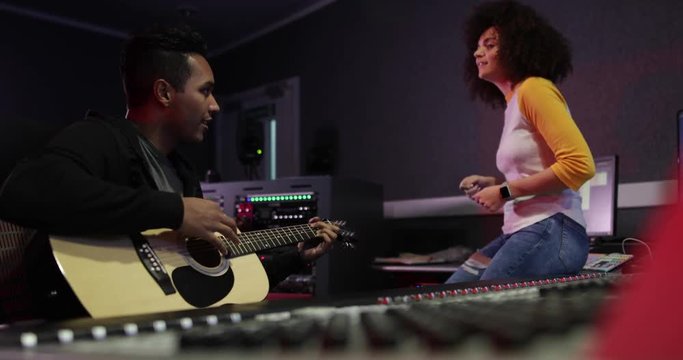 Band working on a track together in a recording studio
