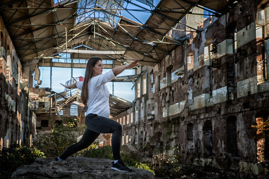 Girl doing yoga in an old abandoned building