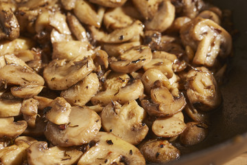 Button mushrooms frying in olive oil and garlic