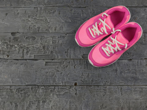 Beautiful pink women's running shoes dark vintage on the floor. The view from the top.