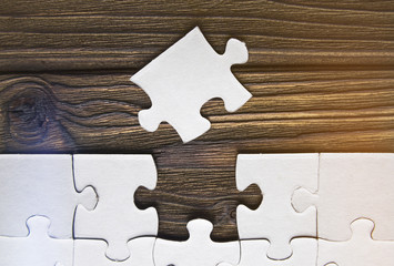 puzzles on a wooden background. Concept business. Idea: working in a team. Close up.