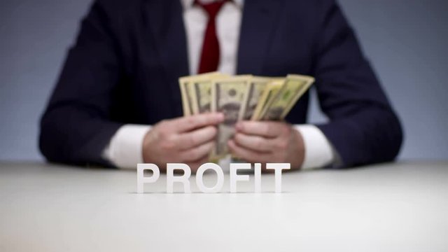 Male hands counting profit in bundle of money. Monetary profit young businessman
