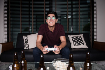 The avid gamer,young asian man playing video games at home © Ratthaphon Bunmi