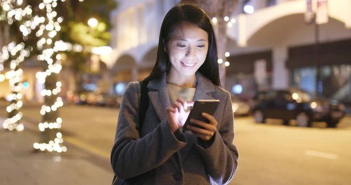 Woman look at smart phone in city