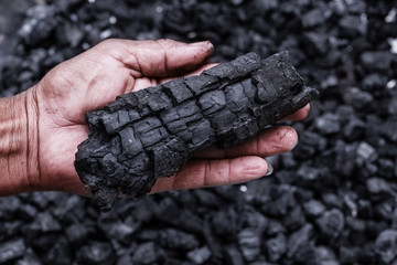 Coal mining - Man hand holding natural black charcoal for background. Picture idea about coal mining, coal processing, energy source, environment protection. Industrial coals. Forest conservation