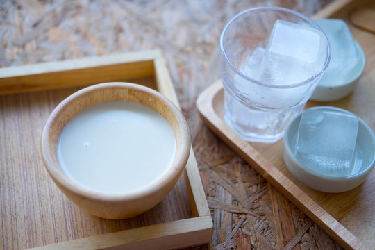Fresh milk in wooden cup served with ice