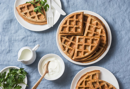 Savory gluten free breakfast waffles on a blue background, top view. Vegetarian food concept