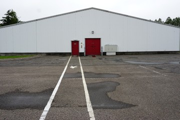 Pathway to red door in white building