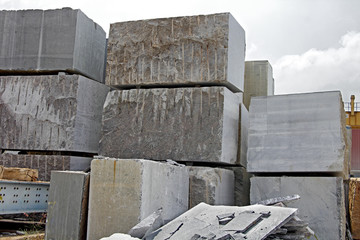 Stacks of heavy granite stones extracted from natural stone quarry. These blocks are processed by...