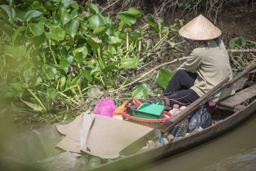 Vietnamese women in boat picking the leafs