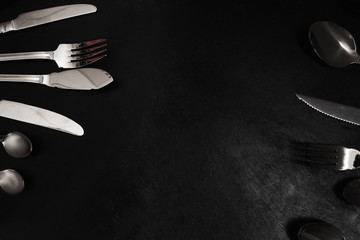 Silver cutlery on black background. Table setting for banquet concept © Photodrive