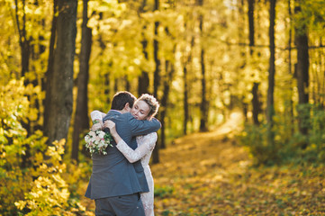 The bride and groom on the background of the brightly lit Golden autumn