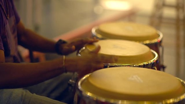 Close up unrecognizable musician is playing congas with music stand.