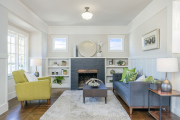 Living room interior with fire place, hardwood floors, fluffy rug and designer furniture.