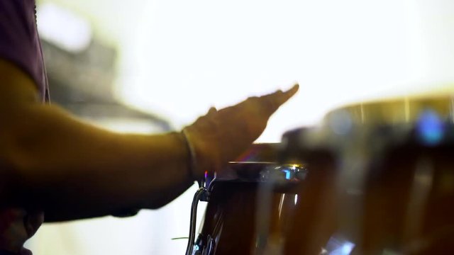 Close up unrecognizable musician is playing congas with music stand.
