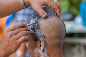 Buddhist monks shave their hair to be ordained a priest.- (Selective focus)