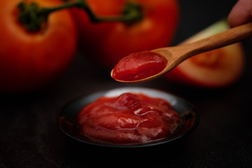 Still life of fresh ripe tomatoes sauce on wooden background,