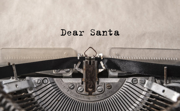 Dear Santa printed on an old vintage typewriter, close-up. Letter to Santa Claus with wishes for gifts, Christmas, New Year.