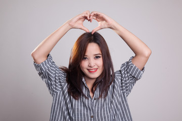 Fototapeta premium Young Asian woman gesturing heart hand sign.