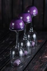 French blueberry mousse cake served on inverted wine glasses on wood background