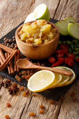 Indian cuisine: apple chutney with lemon and spices close-up on the table. vertical