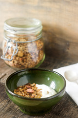 Useful breakfast is yoghurt with granola. Granola with yoghurt in a ceramic bowl and granola in a glass.