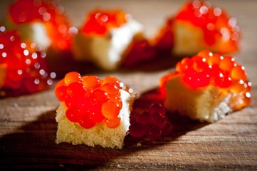 Red caviar with bread and butter on a dark background