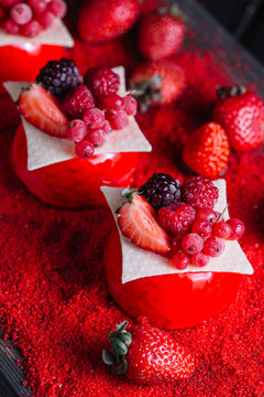 French berries mousse cake served on red sugar on wood background