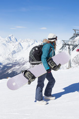 Fototapeta na wymiar Snowboarder girl on the background of the mountains.