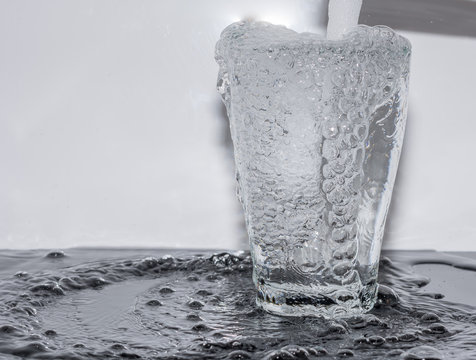 Wasserglas mit Wasser füllen - überlaufen