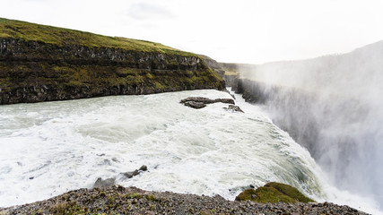 flow of Gullfoss waterfall and spray over canyon