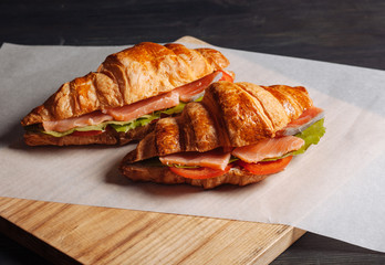 Tasty croissants with salmon on the table